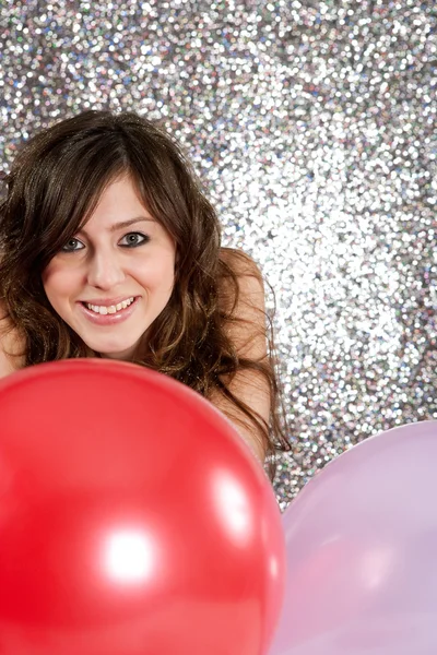 Retrato de uma jovem atraente contra um fundo glitter prata — Fotografia de Stock