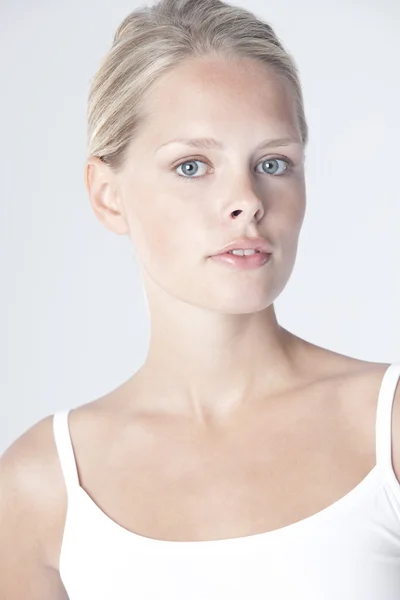 Portret van een mooie jonge vrouw met een wit t-shirt close-up. — Stockfoto