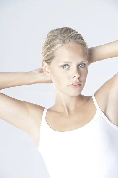 Porträt einer jungen blonden Frau, die ihre Haare berührt. — Stockfoto