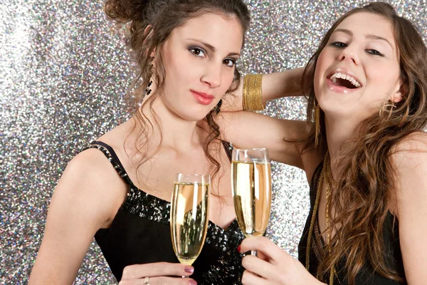 Due giovani donne brindano con champagne a una festa Foto Stock