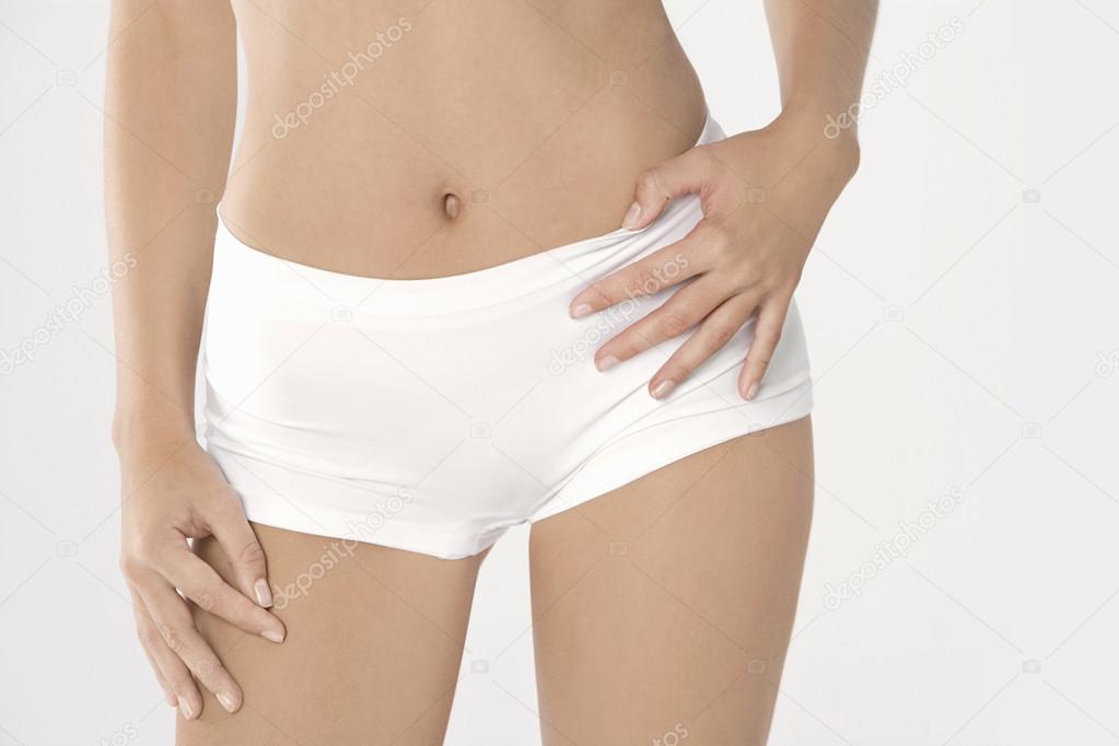 Mid section of a woman wearing white underwear.