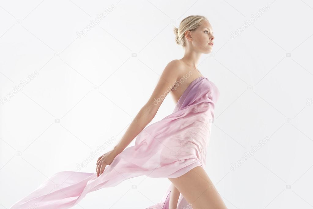 Attractive young woman wearing transparent silk fabric.