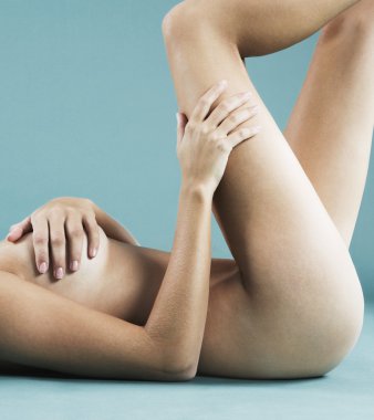 orta gövde bölümüne tabaklanmış çıplak bir kadın bir mavi arka planı bırakmasını.