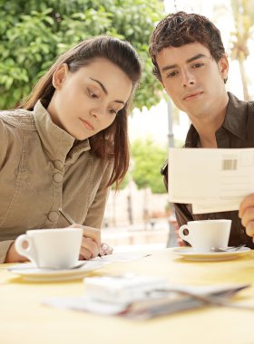 Teras kafede otururken kartpostal yazma çekici çift