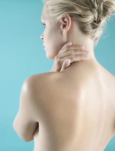 La espalda desnuda de la mujer con la mano en el cuello . — Foto de Stock