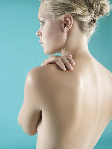 Der nackte Rücken der Frau mit der Hand auf der Schulter. — Stockfoto