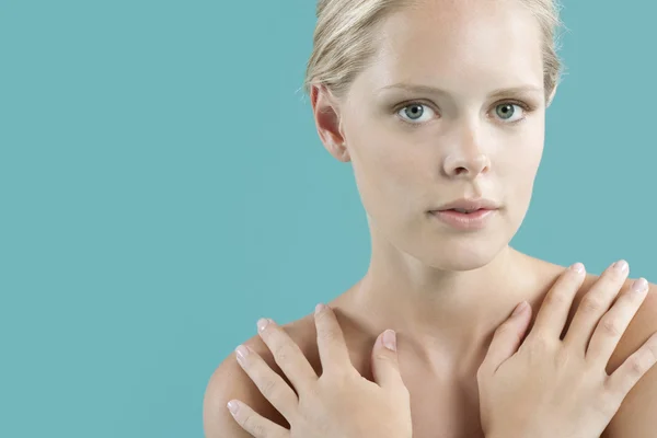 Portrait of a young woman with her hands covering her bare shoulders. — Stock Photo, Image