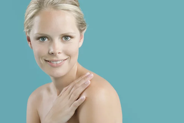 Young woman with her hand covering her bare shoulder. — Stock Photo, Image