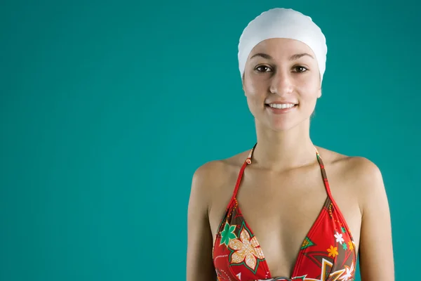 Young swimmer wearing a white rubber had and a floral swimming costume — Stock Photo, Image