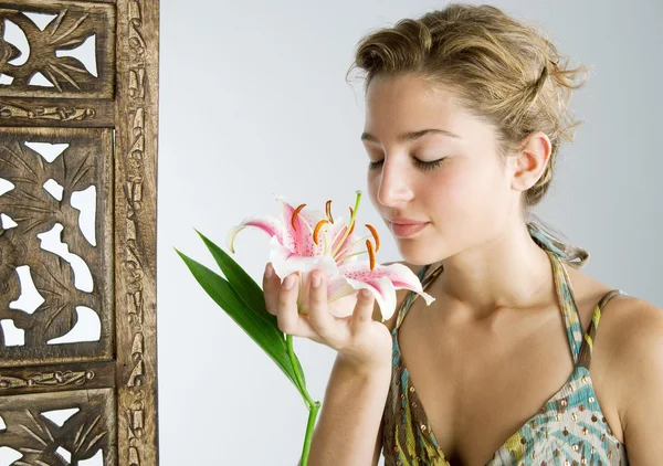 Jovem atraente segurando uma flor lírio japonês em sua mão — Fotografia de Stock