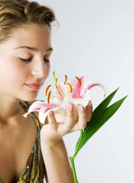 Aantrekkelijke jonge vrouw met een Japanse lilly bloem in haar hand — Stockfoto