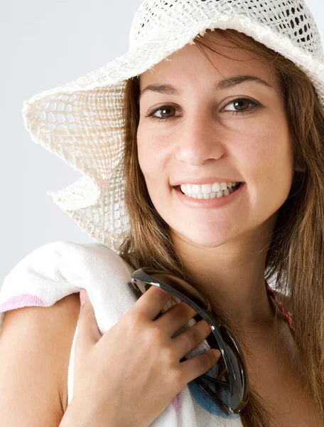 Adolescente con un sombrero de paja de playa y sonriendo a la cámara . —  Fotos de Stock
