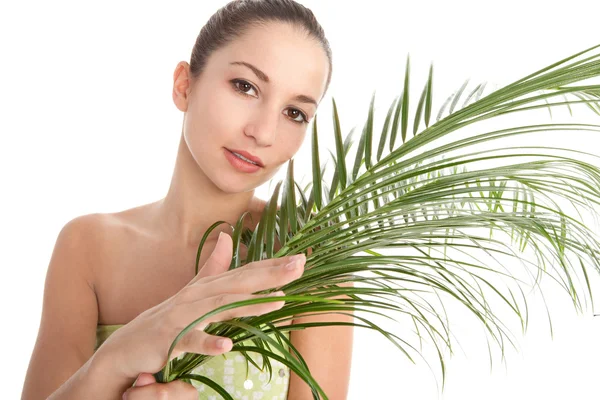 Young woman holding a palm tree leaf — Stock Photo, Image