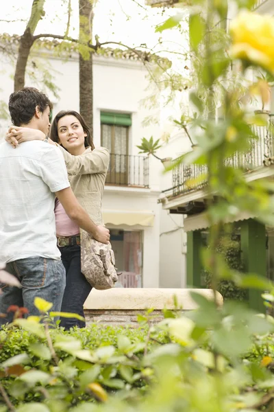 Young tourist couple holding each other in a town square — Stock Photo, Image