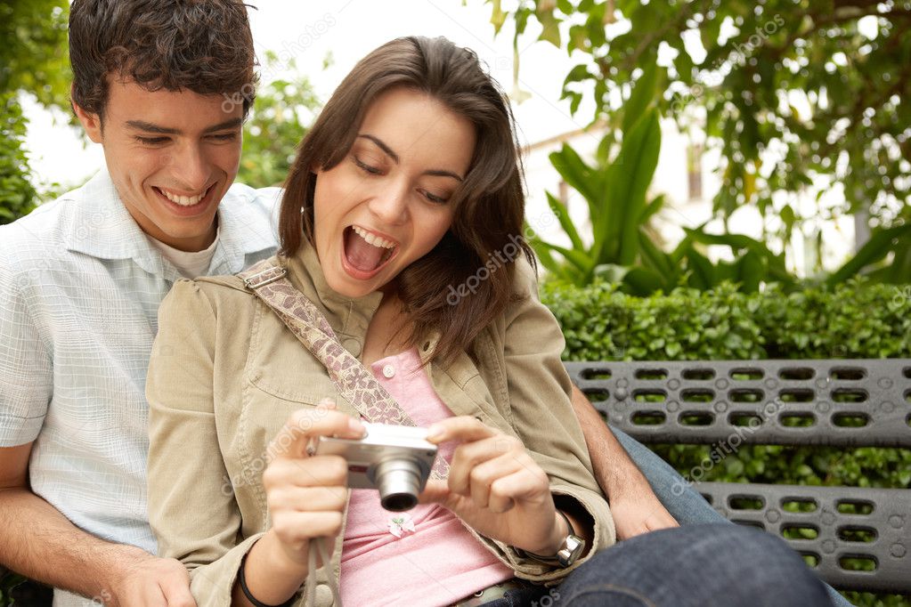 Young couple looking at their holiday pictures on a digital photo camera