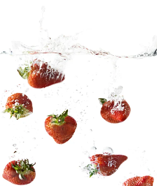 Vue latérale des fraises tombant dans l'eau claire — Photo