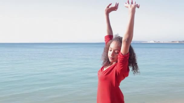 Girl stretching her arms while standing by the sea. — Stock Video