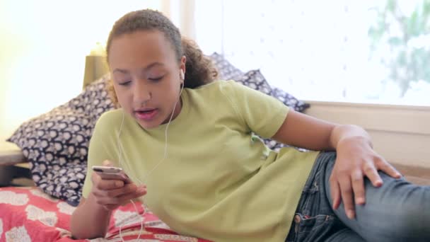 Müzik dinlemek için bir akıllı telefon aygıtı kullanan genç kız — Stok video