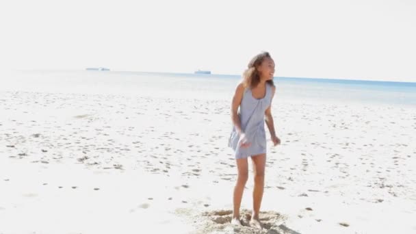 Kız beyaz kum plaj üzerinde atlama. — Stok video