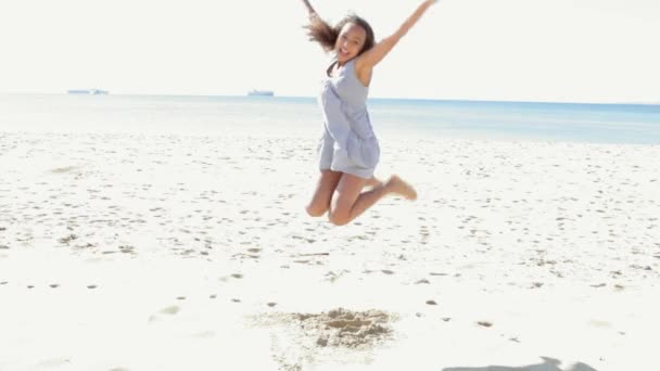 Fille sautant sur une plage de sable blanc . — Video