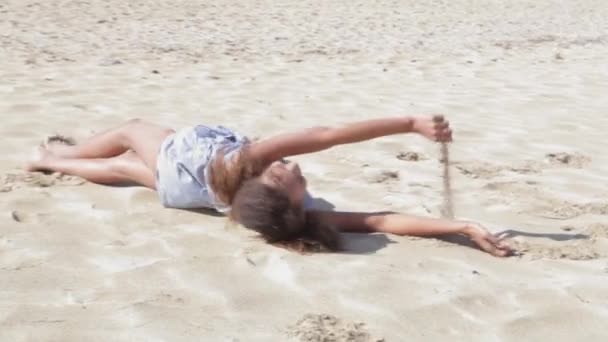 Gördülő a homokot egy fehér strand lány. — Stock videók