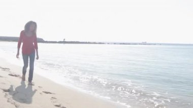 genç kız kameraya yaklaşırken Sahilde yürüyüş