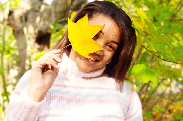 Girl holding a yellow dry autumn leaf — Stock Photo, Image