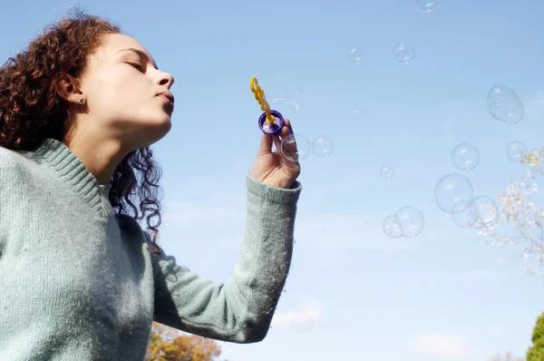 Girl blowing soap bubbles — Stock Photo, Image