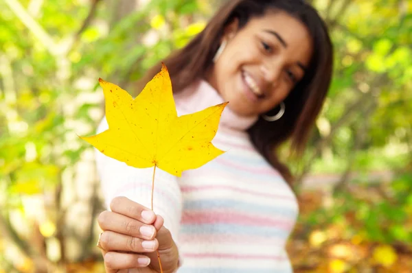 Girl holding a yellow dry autumn leaf — Stock Photo, Image