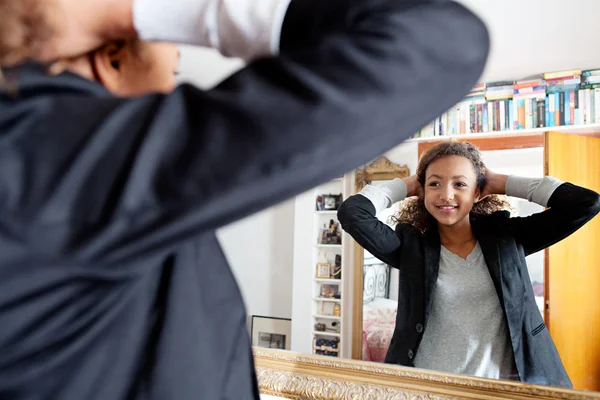 Meisje kijkend naar zichzelf in de spiegel — Stockfoto