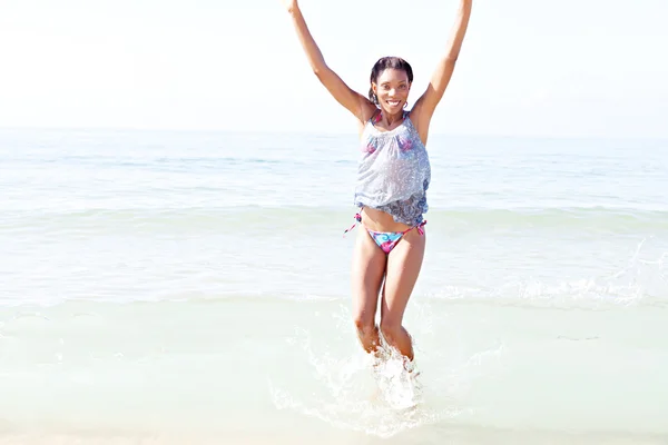 Woman jumping on the shore — Stock Photo, Image