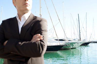 Businessman standing by a luxurious yachts clipart