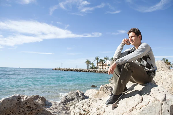 Homme assis sur le rivage — Photo