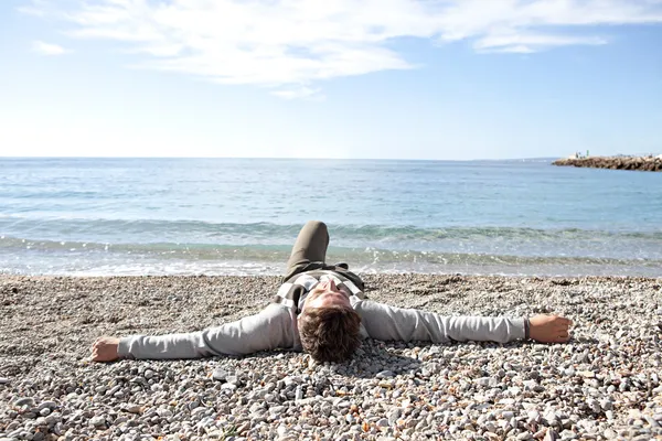 Man sitting down on the shore — Stock Photo, Image