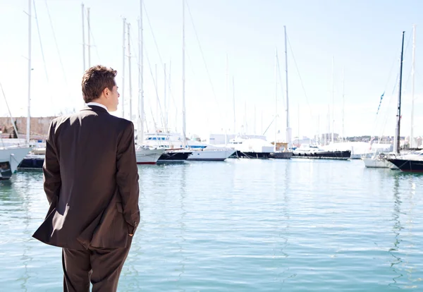 Uomo d'affari in piedi da barche a vela costosi — Foto Stock