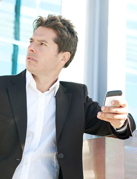 Hombre de negocios profesional sosteniendo un teléfono inteligente — Foto de Stock