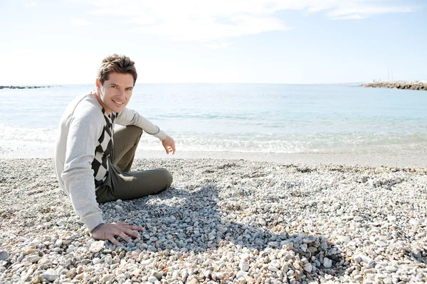 Man sitting down on the shore — Stock Photo, Image