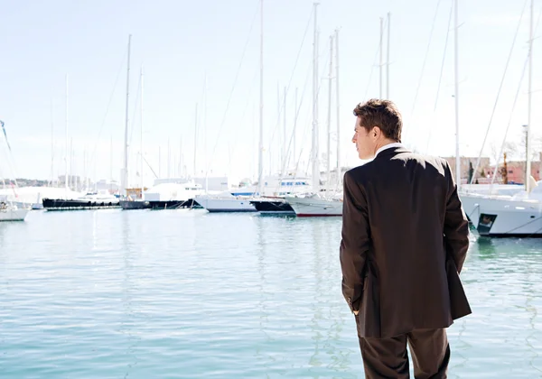 Businessman standing by expensive sailing boats — Stock Photo, Image