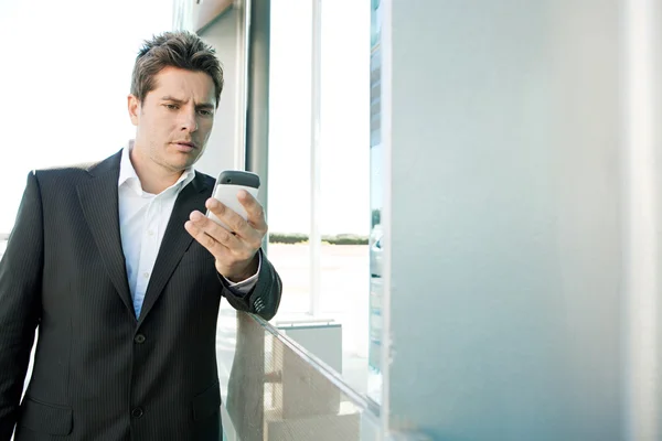 Homem de negócios segurando um telefone inteligente — Fotografia de Stock