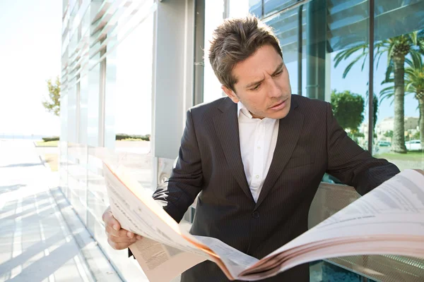 Businessman standing by a modern office building — Stock Photo, Image