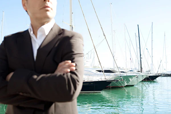 Businessman standing by a luxurious yachts — Stock Photo, Image