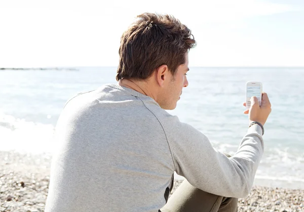 Man sitting down on the shore — Stock Photo, Image