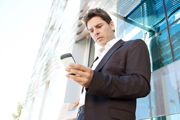 Affärsman som innehar en smart telefon — Stockfoto