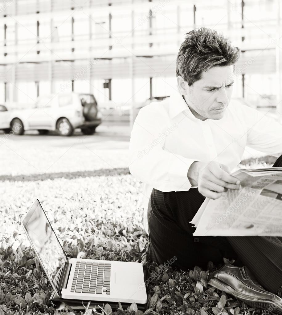 Business man reading a financial newspaper