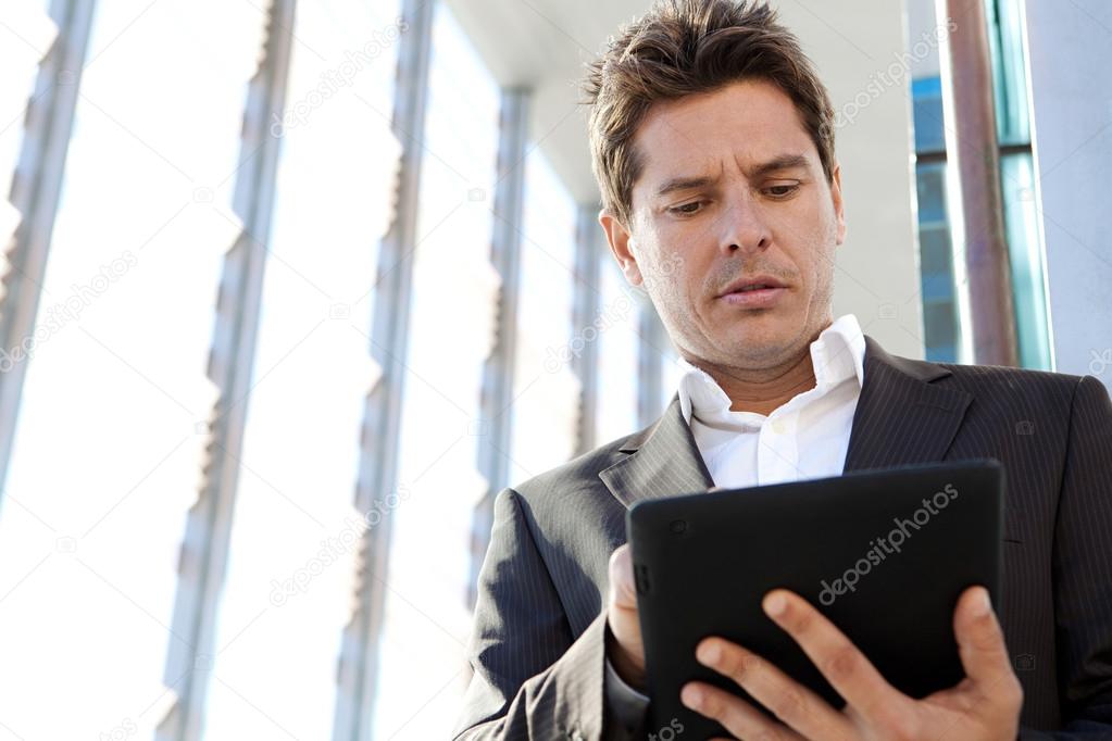 Businessman standing by a modern glass office