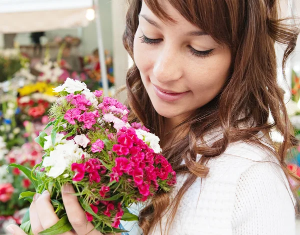 Mulher cheirando f flores — Fotografia de Stock