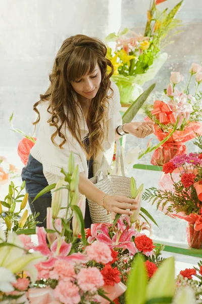 Mulher escolhendo cacho de flores — Fotografia de Stock