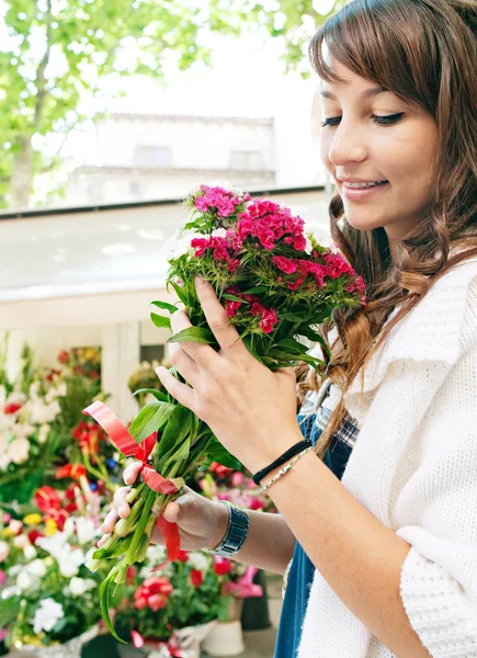 Frau riecht nach Blumen — Stockfoto