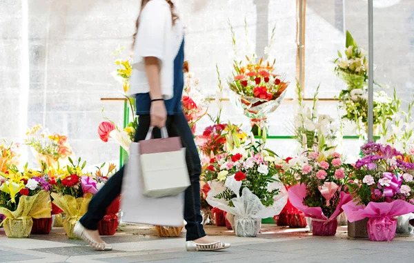 Mujer caminando pasado flores mercado —  Fotos de Stock