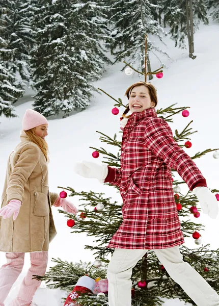 Девушки бегают вокруг рождественской елки — стоковое фото